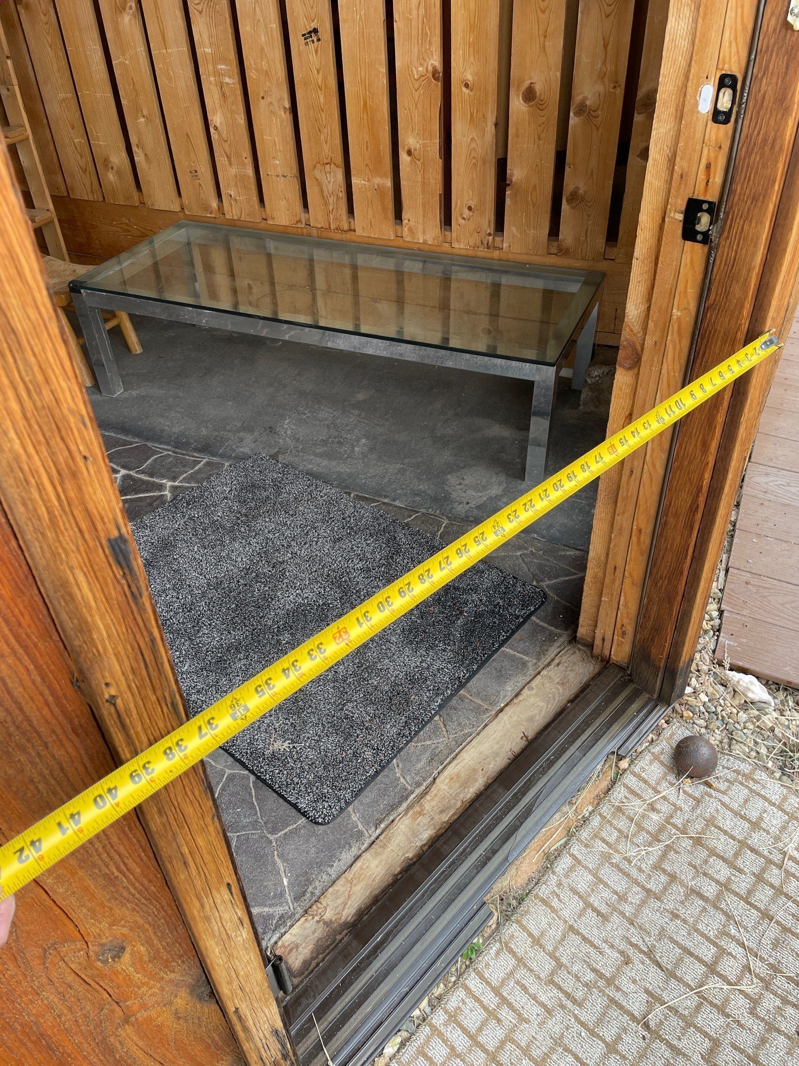Puerta de madera con un panel de vidrio y un metro a través de ella.