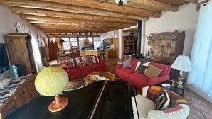 A cozy living room with a piano, a globe, and a red sofa.
