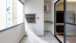 Un pasillo estrecho con una hamaca, un estante empotrado pequeño y un aire acondicionado de pared.