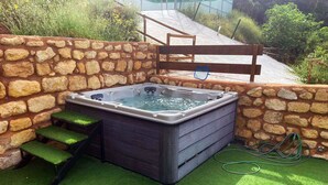 A hot tub in a stone-walled outdoor area with steps leading up to it. - Rural house torre chica located in frailes jaen in the middle of nature (frailes)