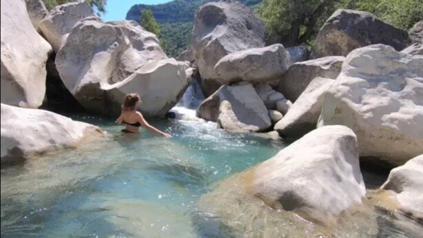 A woman in a natural setting with clear water and large rocks. - Chalet 2: Breakfast optional  (Aouste-sur-Sye)