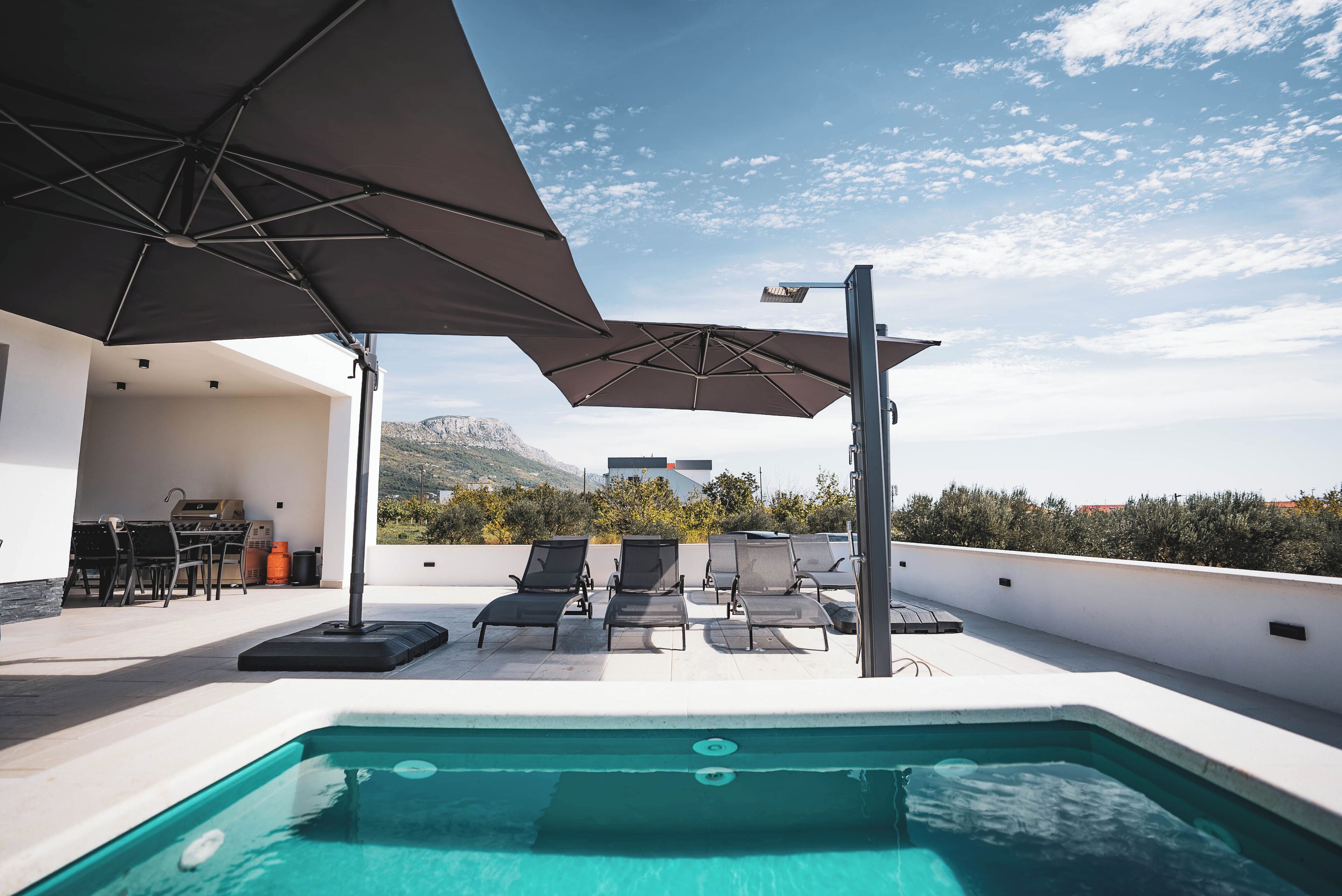 室外游泳池，提供泳池遮陽傘和日光浴躺椅