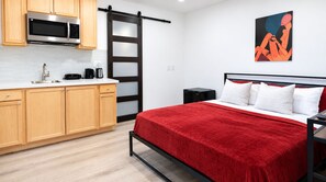 Ein modernes Schlafzimmer mit einem Bett, Nachttischen und einer roten Decke.