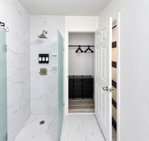 Ein Badezimmer mit Dusche, Toilette und Stauraum.