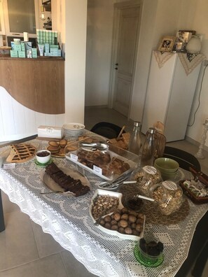 Una mesa con diversos alimentos y recipientes, un espejo y una estantería con productos.