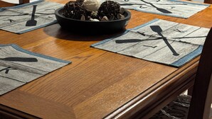 Une table à manger avec des sets de table, un bol de collations et des couverts.