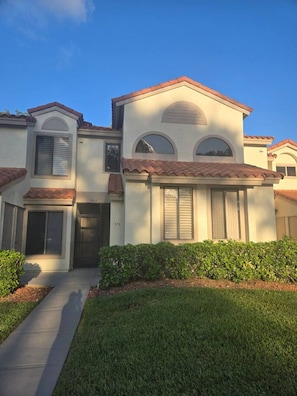 A two-story house with a front entrance, a covered porch, and a well-maintained lawn.
