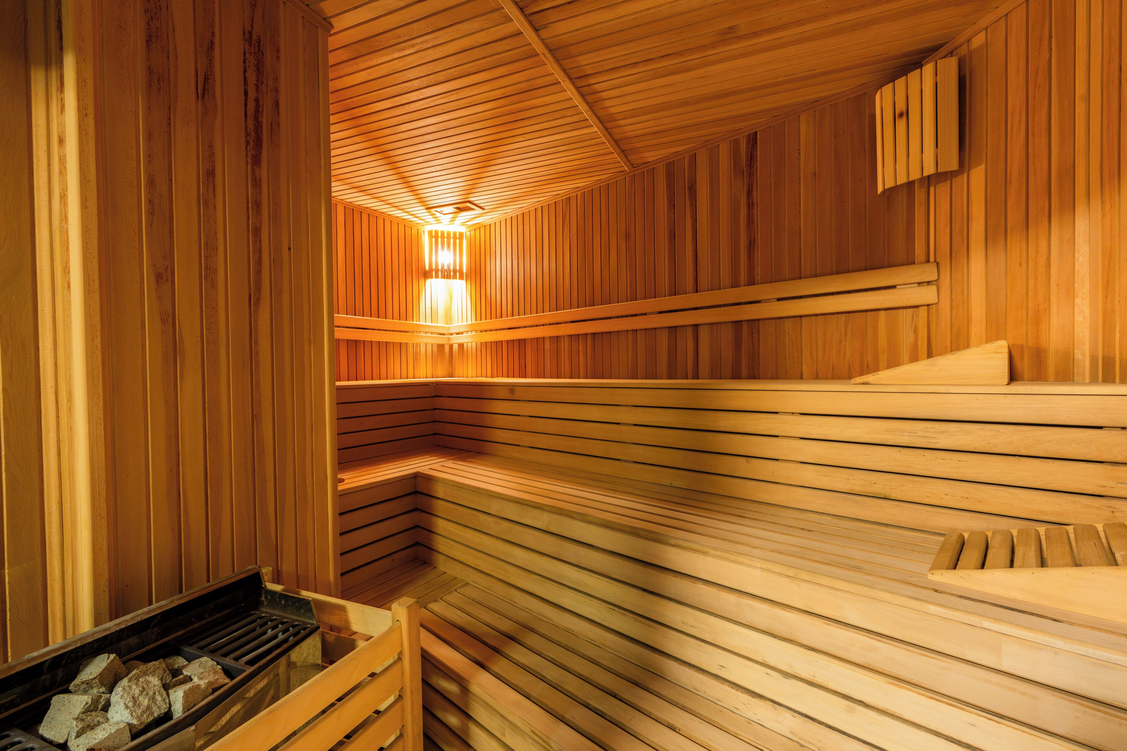 Una sauna con bancos de madera y un elemento calefactor de piedra.