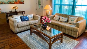 A living room with two sofas, a coffee table, and a painting on the wall. - Angie's Family-Favorite Lake Home: Heated Pool 3br/3ba (Port Richey)