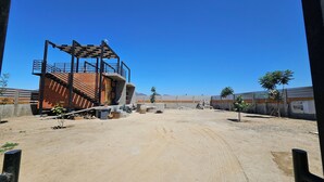 Un chantier de construction avec une structure en briques partiellement achevée et des échafaudages.