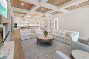 A spacious living room with a large sectional sofa, a round coffee table, and a fireplace.