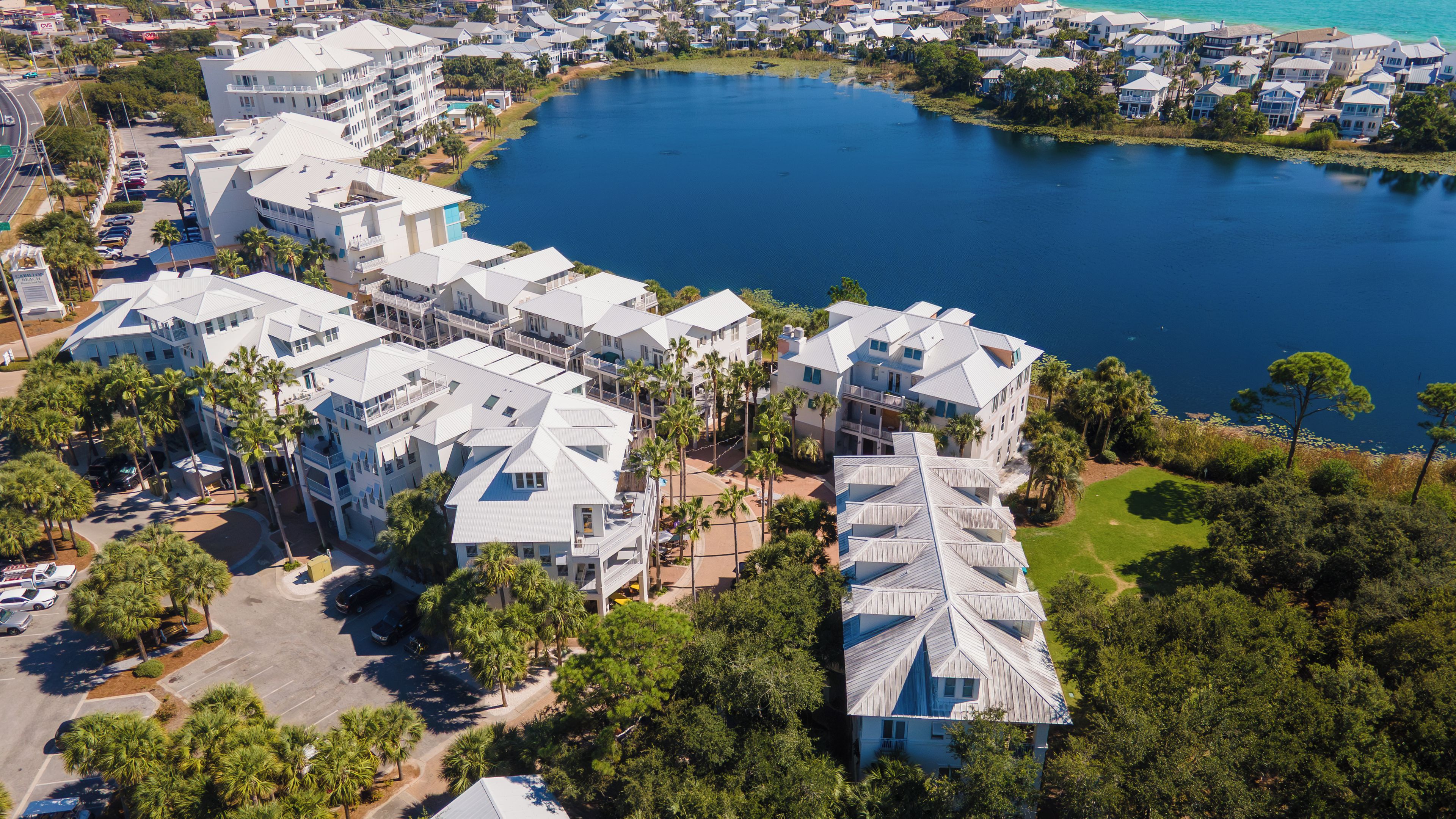 A coastal residential area with multiple-story buildings, a marina, and a large body of water.