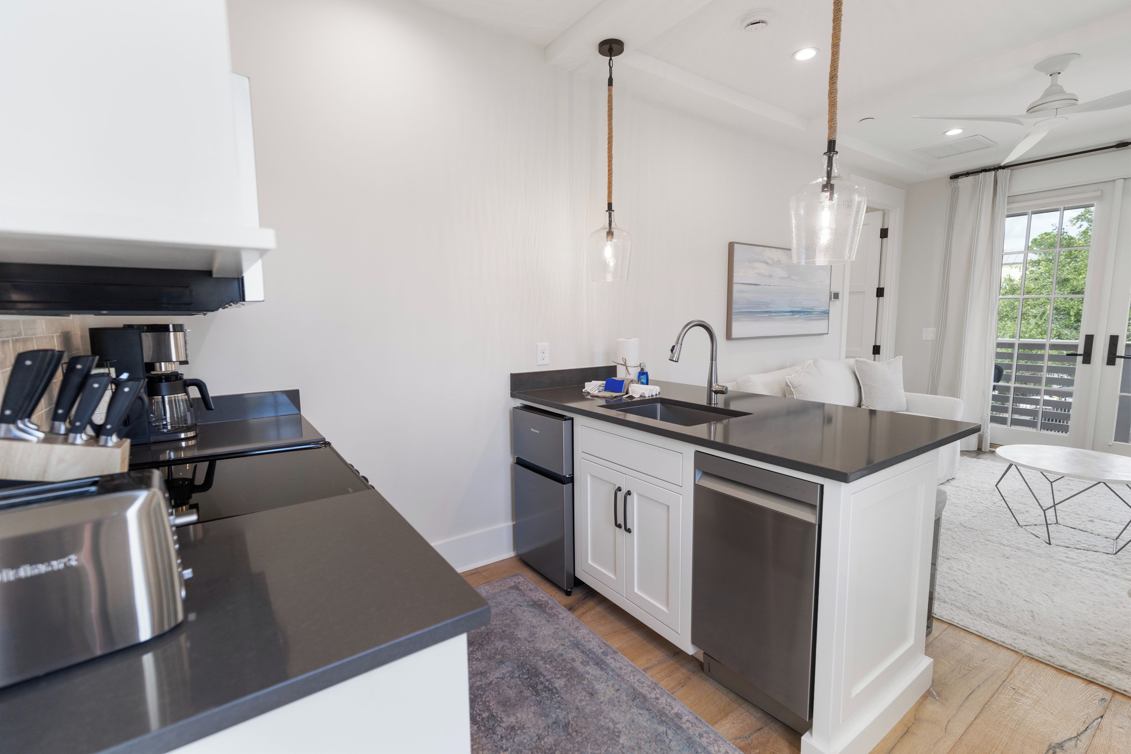 A modern kitchen with stainless steel appliances, a central island, and pendant lighting.