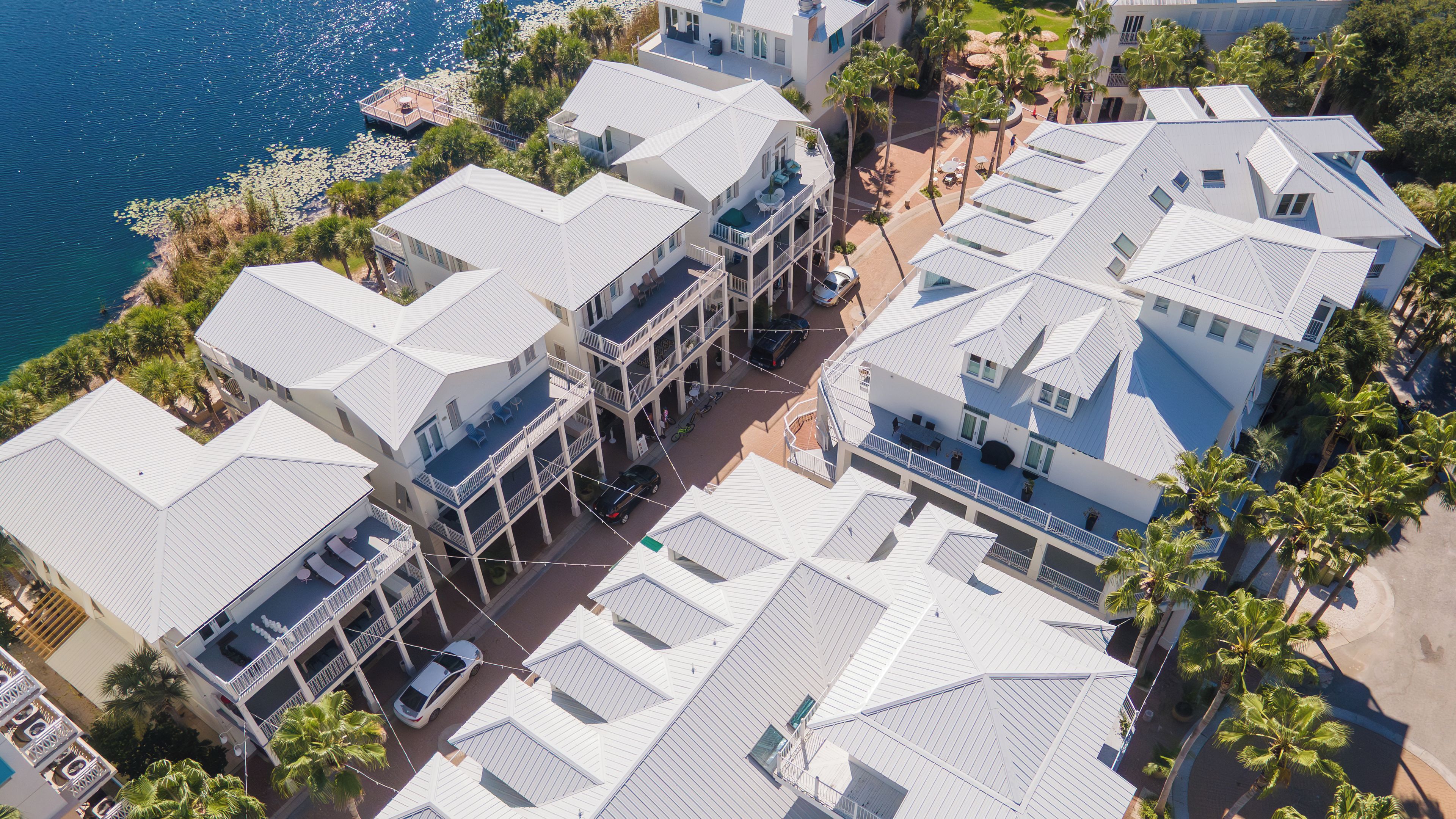 Un hotel costero con varios balcones, una zona de piscina y vistas al mar.