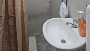 Ein Badezimmer mit Dusche, Waschbecken und Spiegel.