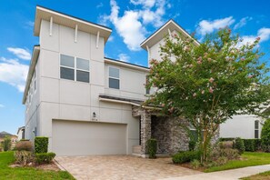 A two-story residential building with a stone entrance and a garage.