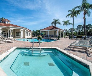 A resort with a swimming pool, lounge chairs, and palm trees. - 7/5.5 Beautiful Vacation home with private pool, and much more!! (Kissimmee)