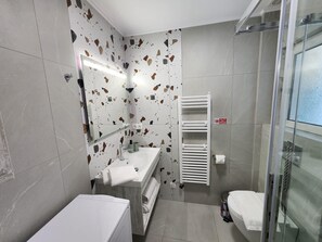 A modern bathroom with a white sink, a glass shower enclosure, and a tiled floor. - Smile in the the Center of Athens &Breakfast optional (Athina)