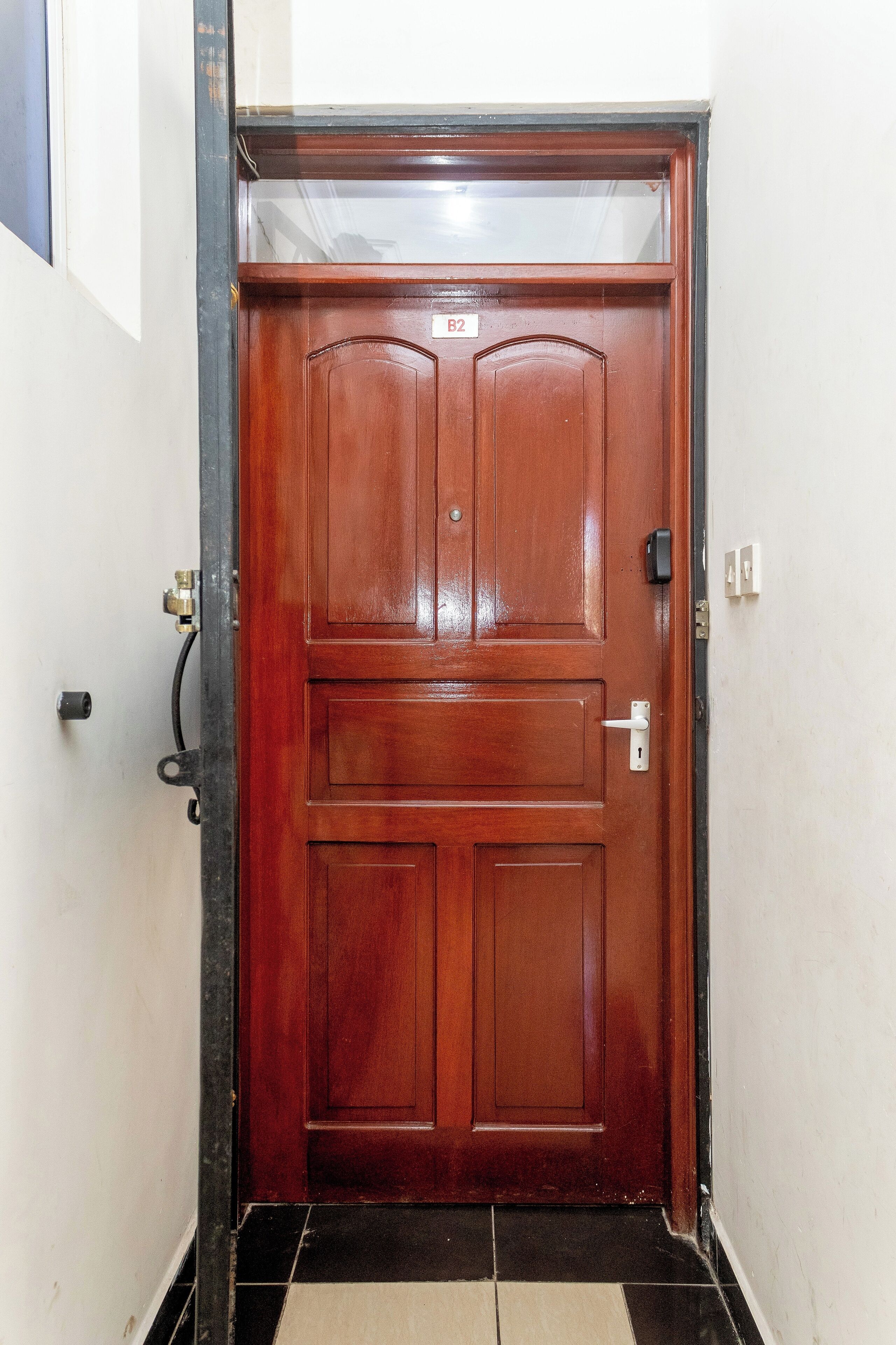 A wooden door with a number plate, a keyhole, and a door handle.