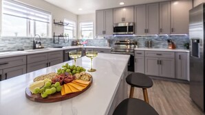 A modern kitchen with a marble countertop, a built-in oven, and stainless steel appliances. - Hot Tub w Mountain View Pets OK (Westminster)