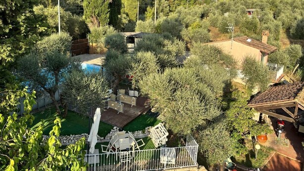 A residential area with a swimming pool, a wooden deck, and a small house with a tiled roof. - Shelter among olive trees, Tuscan countryside, a stone's throw from characteristic cities (Toscana)