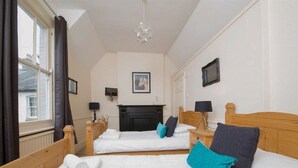 A hotel room with two beds, a fireplace, and a view of the outside. - The Wheatsheaf (Newmarket)