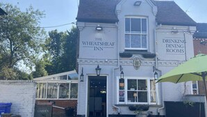 The Wheatsheaf Inn with a sign for 'Drinking Dining Rooms' and a 'Garden' sign visible. - The Wheatsheaf (Newmarket)