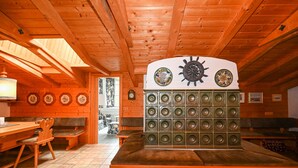 A wooden interior with a long table, chairs, and a wall-mounted speaker system.