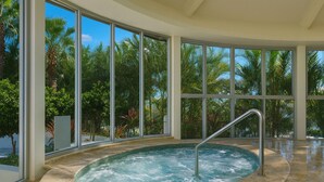 A hot tub with a metal ladder, surrounded by large windows offering a view of palm trees and the ocean. - Ocean View Rental Surfers Paradise (Surfers Paradise)