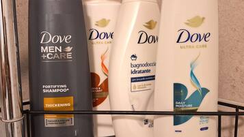 En badrumshylla med Dove-produkter för män, inklusive ett stärkande schampo, ett återfuktande schampo för daglig användning och en återfuktande duschkräm.