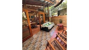 A spacious room with a patterned floor, wooden furniture, and a large bed with a green blanket.
