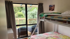 Una habitación con literas, un escritorio y una ventana con cortinas.