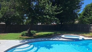 A swimming pool with a curved design and multiple steps leading into the water.