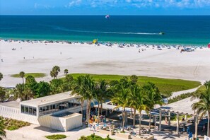 A beach resort with a modern building, palm trees, and a view of the ocean.