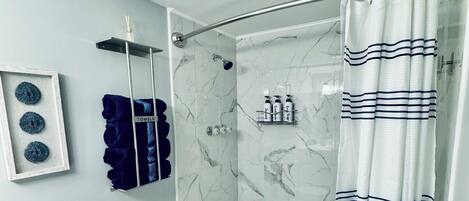 A bathroom with a toilet, bathtub, and shower curtain.