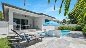 A modern house with a pool, outdoor seating, and a patio area. - New! Sunset Walk – Brand New Luxury Home, Just a Short Stroll to Vanderbilt Beach (Naples)