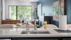 A modern kitchen with a stainless steel sink, a faucet, and a candle on the counter. - PFR Suites - Butler|2-Story Lawrenceville Penthouse w/ Rooftop Terrace|2 King Beds /2.5 Bath|Parking (Pittsburgh)