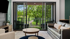 Una sala de estar moderna con un amplio ventanal corredizo que da a un jardín.