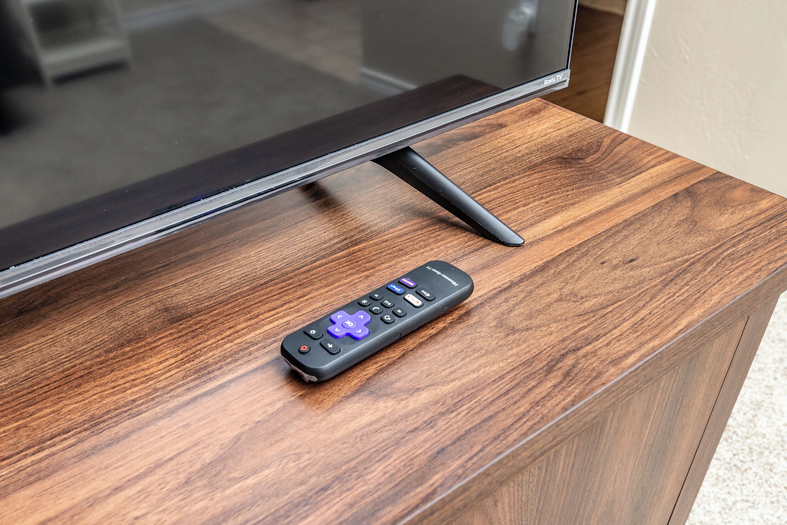 A remote control on a wooden surface.