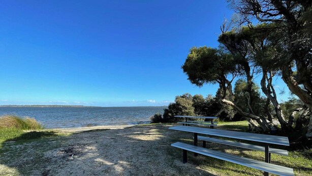 A beach with a bench and trees, overlooking a calm sea. - Wannanup Retreat Short Stay Accommodation. Pet-Friendly! (Wannanup)
