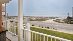 A balcony with a view of a road and beach.