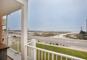 A balcony with a view of a road and beach.