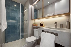 A modern bathroom with a glass shower enclosure, a toilet, a vanity with a mirror, and a towel rack.