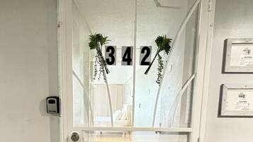 A white door with the numbers 342 and a plant decoration.