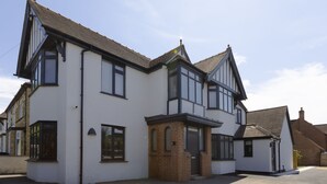 A two-story house with a white exterior, dark trim, and a pitched roof. - Bell House Oxford - The Quill (Oxford)