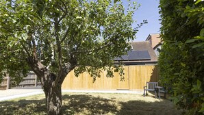 A backyard with a tree, a wooden fence, and a bench. - Bell House Oxford - The Quill (Oxford)