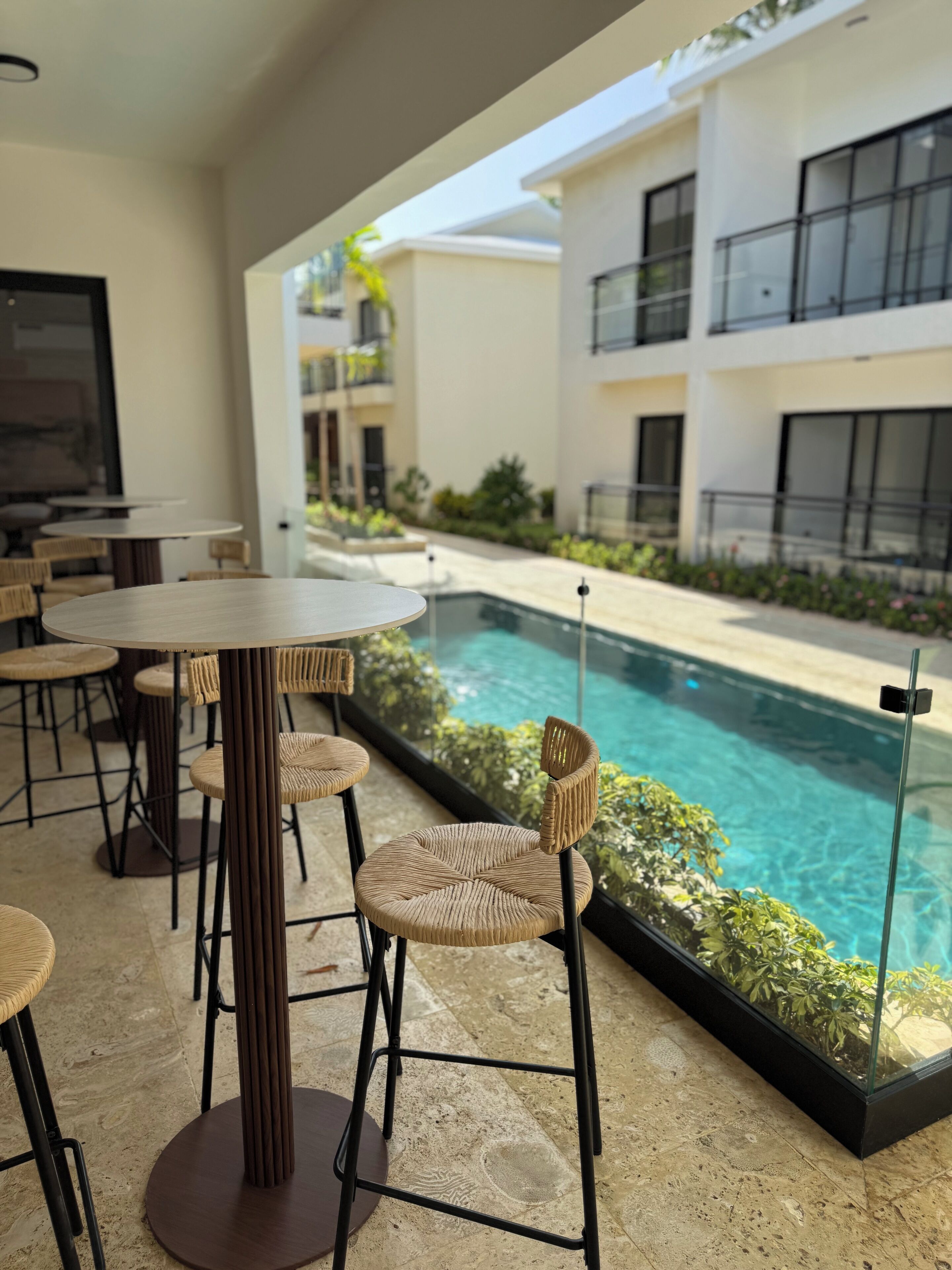 A poolside area with outdoor seating and a view of a modern building.