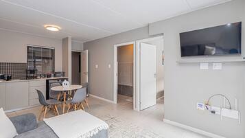 En modern lägenhet med kök, matplats och vardagsrum.