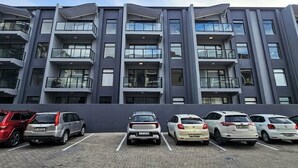 Un edificio moderno de varios pisos con estacionamiento al frente.