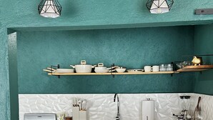 A kitchen with teal walls, a white countertop, and three wooden bar stools. - Cozy Loft Maria Bonita, central to the Magical Town of Valle de Bravo (Valle de Bravo)
